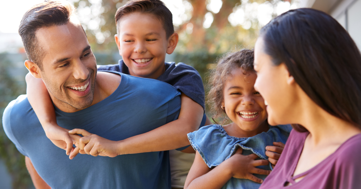 Family of four smiling and laughing